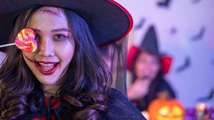 Asian woman wearing a witch costume