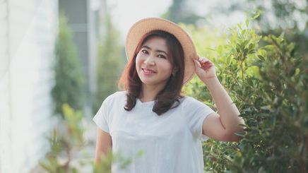 Asian woman wearing a hat outside 