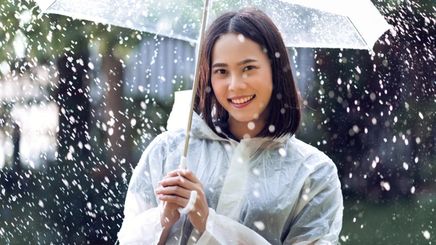 Asian woman carrying an umbrella in the rain