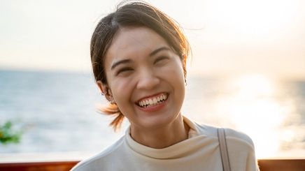 Happy Asian woman by the sea
