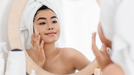 Asian woman applying acne cream