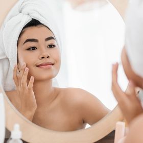 Asian woman applying acne cream