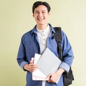 A well-groomed man smiling while carrying folders and a bag.