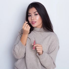 Asian woman applying lip color