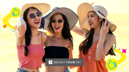 Three ladies out at the beach with large beach hats and sexy clothes on. 