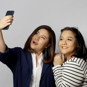 Two Asian women making a selfie to show their layered haircuts 