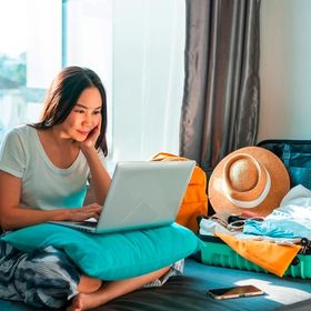 Asian businesswoman working on her laptop while on vacation.