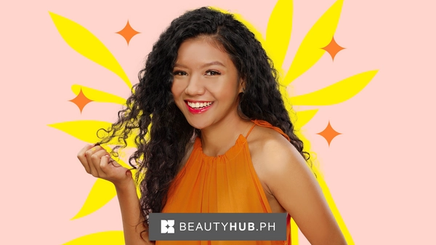 An Asian woman with red lipstick and curly hair 