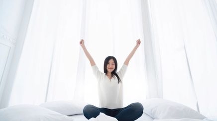 Happy Asian woman on a bed