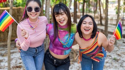 Three Asian friends having fun at a Pride event.