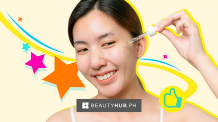 Smiling Asian applying serum on her face with a dropper.