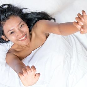 Asian woman with long hair in bed