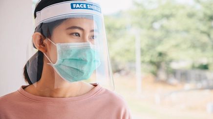 Asian woman wearing face mask and face shield