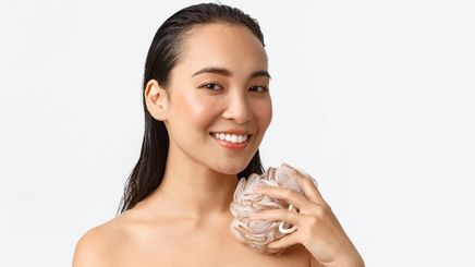Asian woman holding a shower loofah 