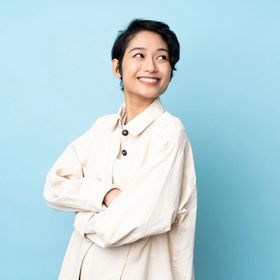 Young Asian woman with short hair against blue background 