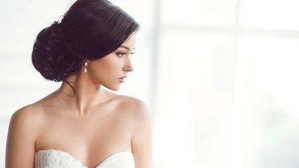 A beautiful bride in chignon hairstyle looking out the window