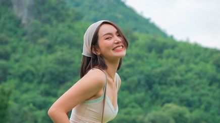 Smiling woman with a bandana on her head, posing outdoors.