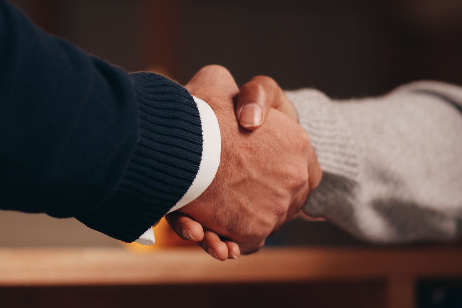 A handshake over a wooden counter