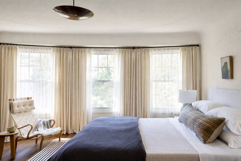 Bed with tailored drapery and a blue coverlet