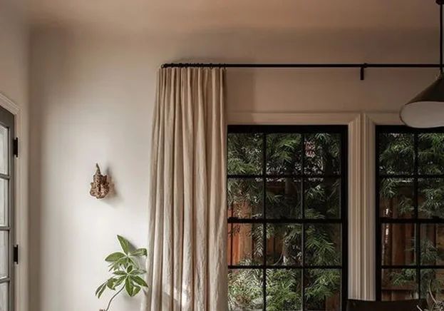 Neutral drapery panels hung on a black iron rod