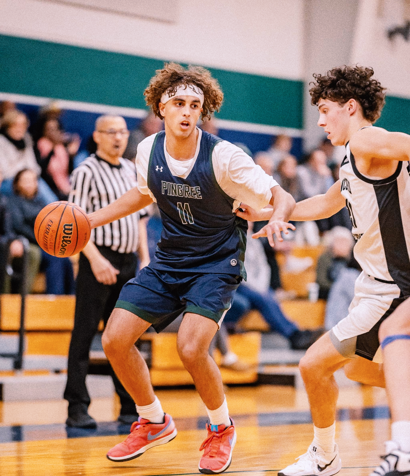 A Pingree guard dribbling past a defender