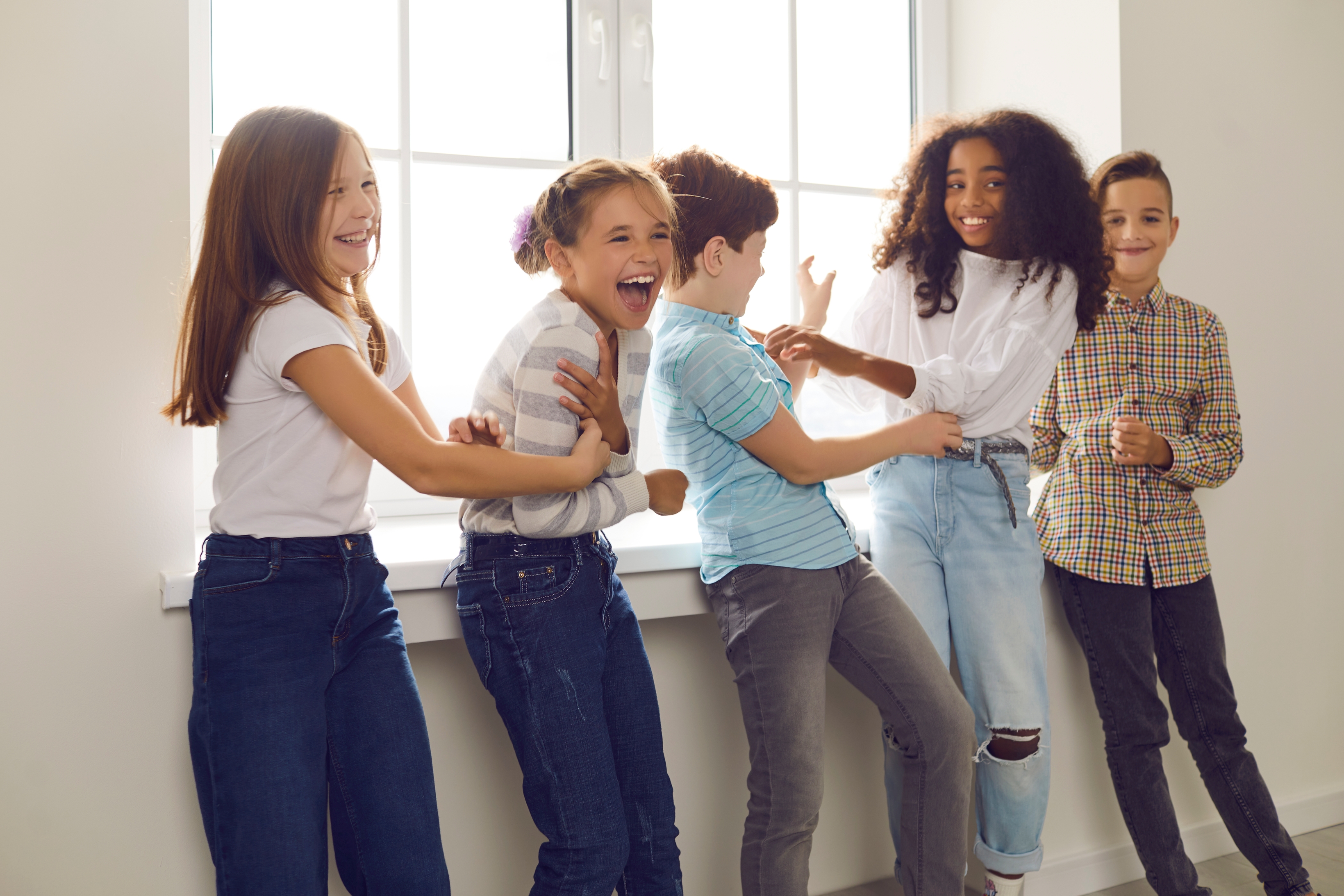 Fem glade under i korridor på skole.