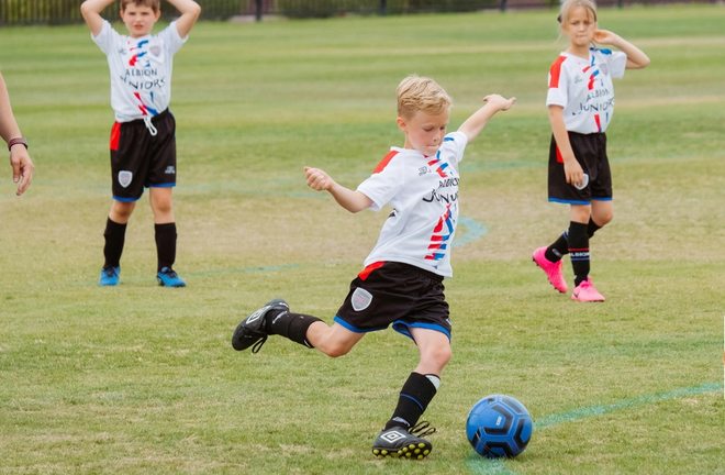 Gutt sparker fotball. Foto: Kenny Elison for Unsplash.