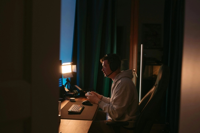 Tenåringsgutt gamer på gutterommet.