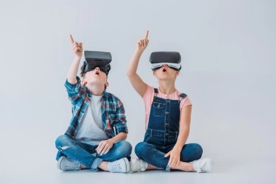 To måpende barn med VR-briller peker opp mot taket.