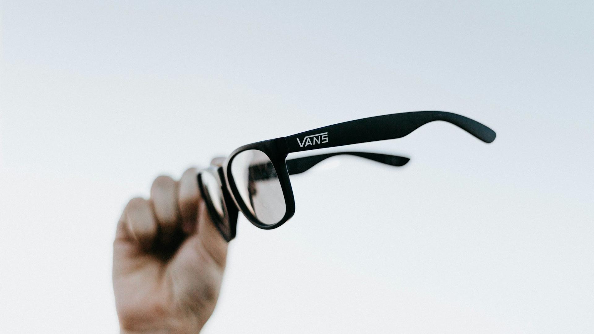 Main tenant une paire de lunettes connectées, l'usage audio et photo au quotidien