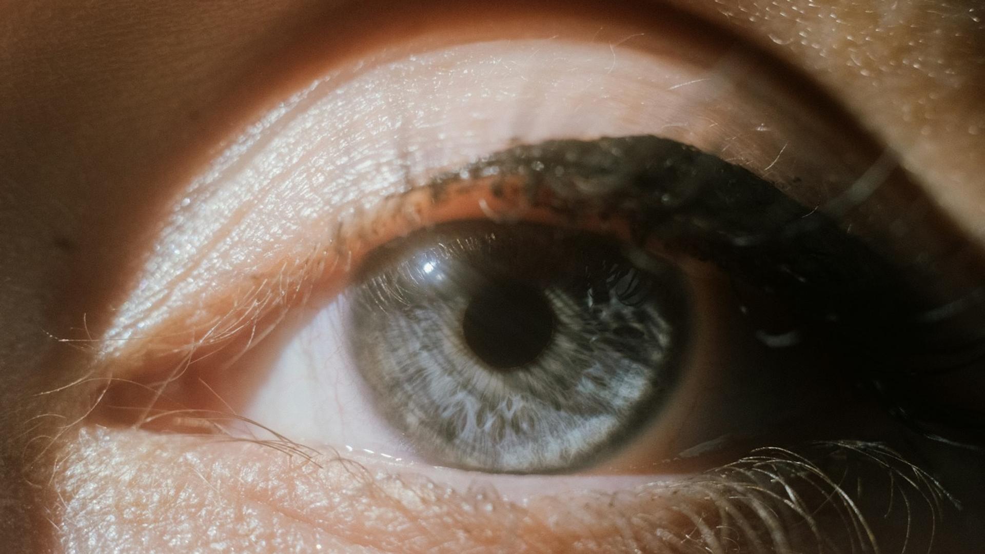 Gros plan sur un œil bleu avec la pupille bien visible au centre de l'iris, illustrant la dilatation de la pupille
