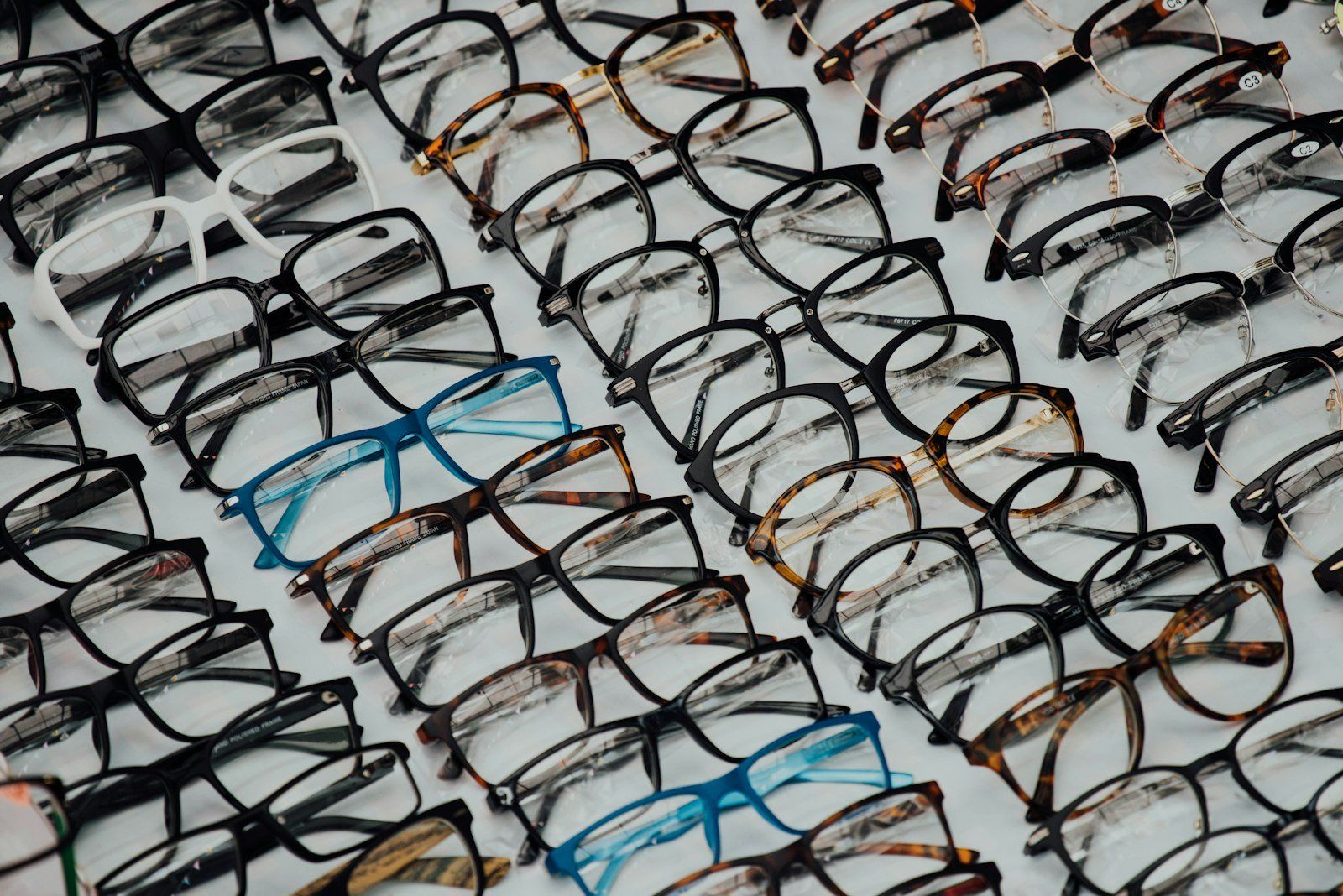 Plusieurs paires de lunettes alignées sur un présentoir, illustrant la diversité des prix selon les montures et les verres