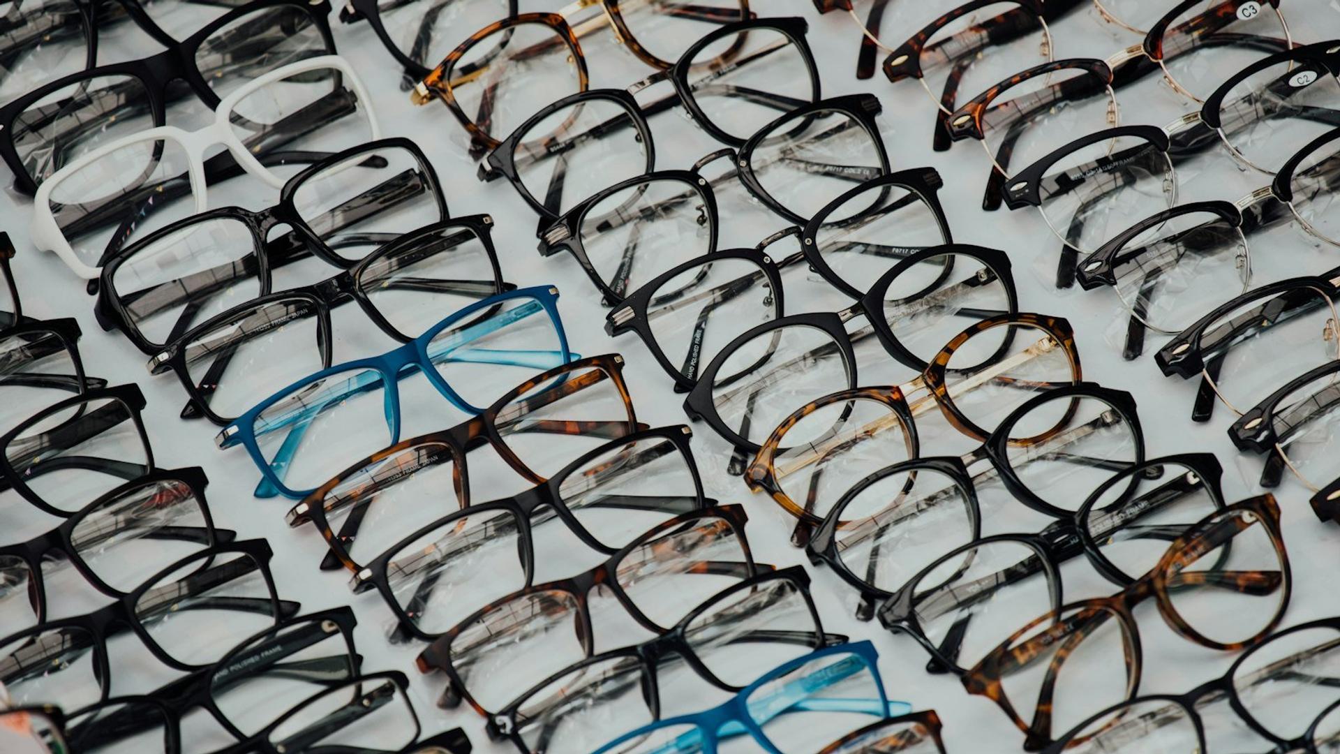 Plusieurs paires de lunettes alignées sur un présentoir, illustrant la diversité des prix selon les montures et les verres