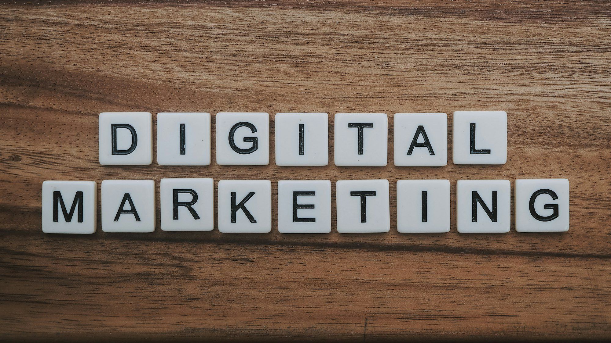 Lettres du jeu de scrabble formant les mots digital marketing sur une surface en bois