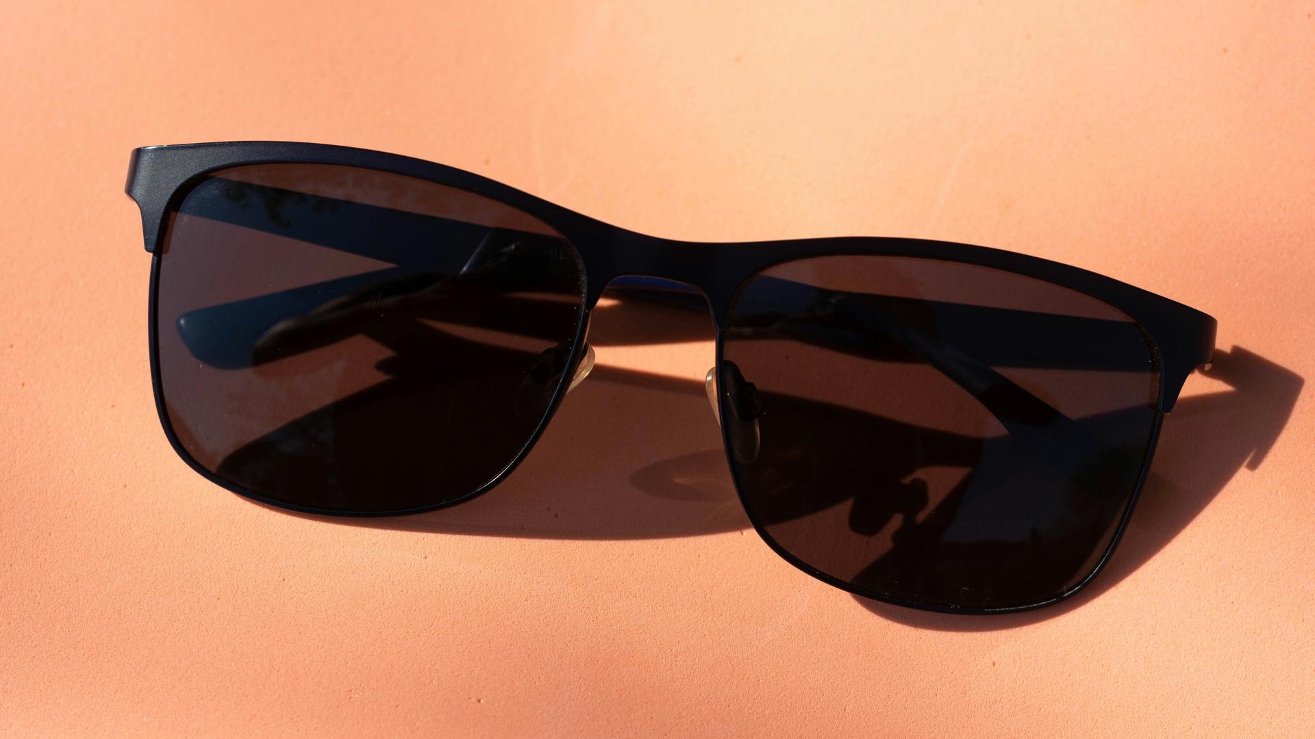 Lunettes de soleil noires sur une table, technologie connectée
