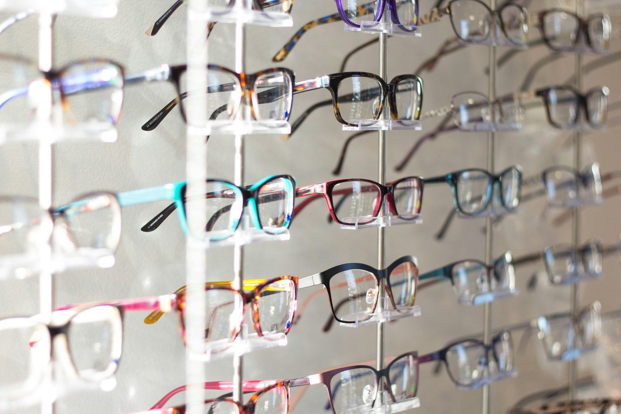 Présentoir de lunettes aux montures colorées dans une boutique d'optique