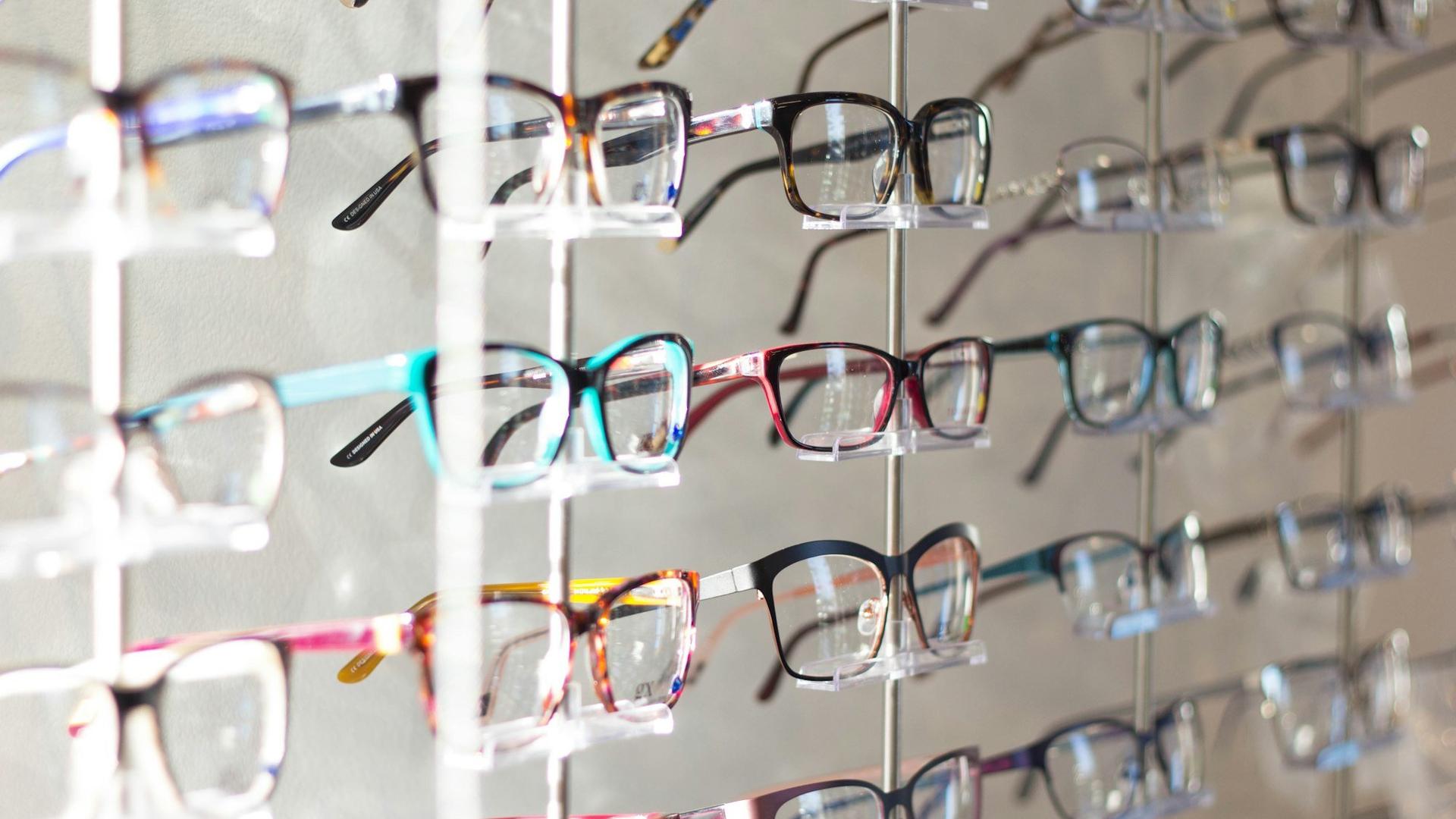 Présentoir de lunettes aux montures colorées dans une boutique d'optique