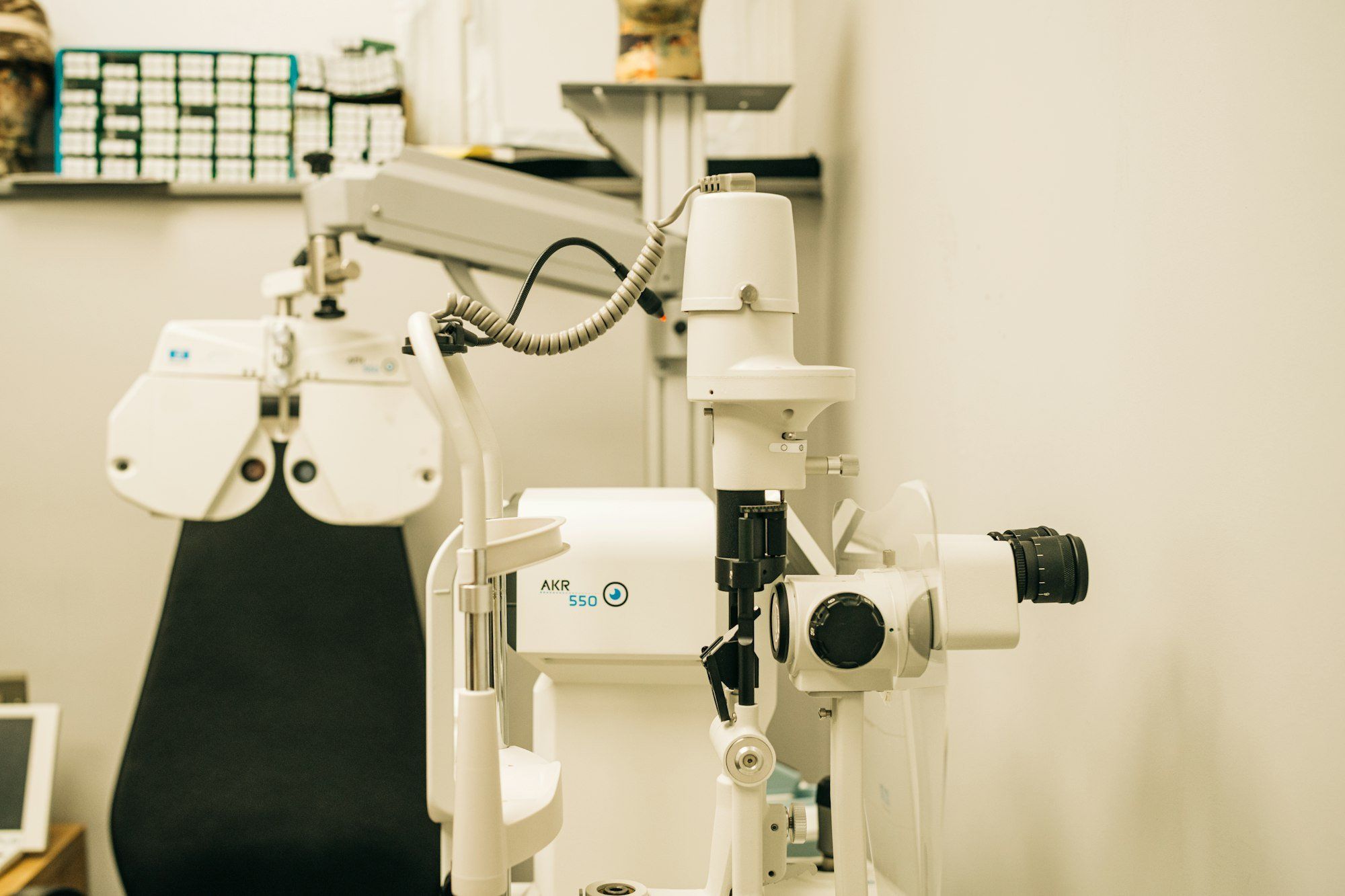 Salle d'examen de vue avec microscope et écran de contrôle, illustrant les services de contrôle et d'adaptation inclus dans le prix d'un opticien indépendant.
