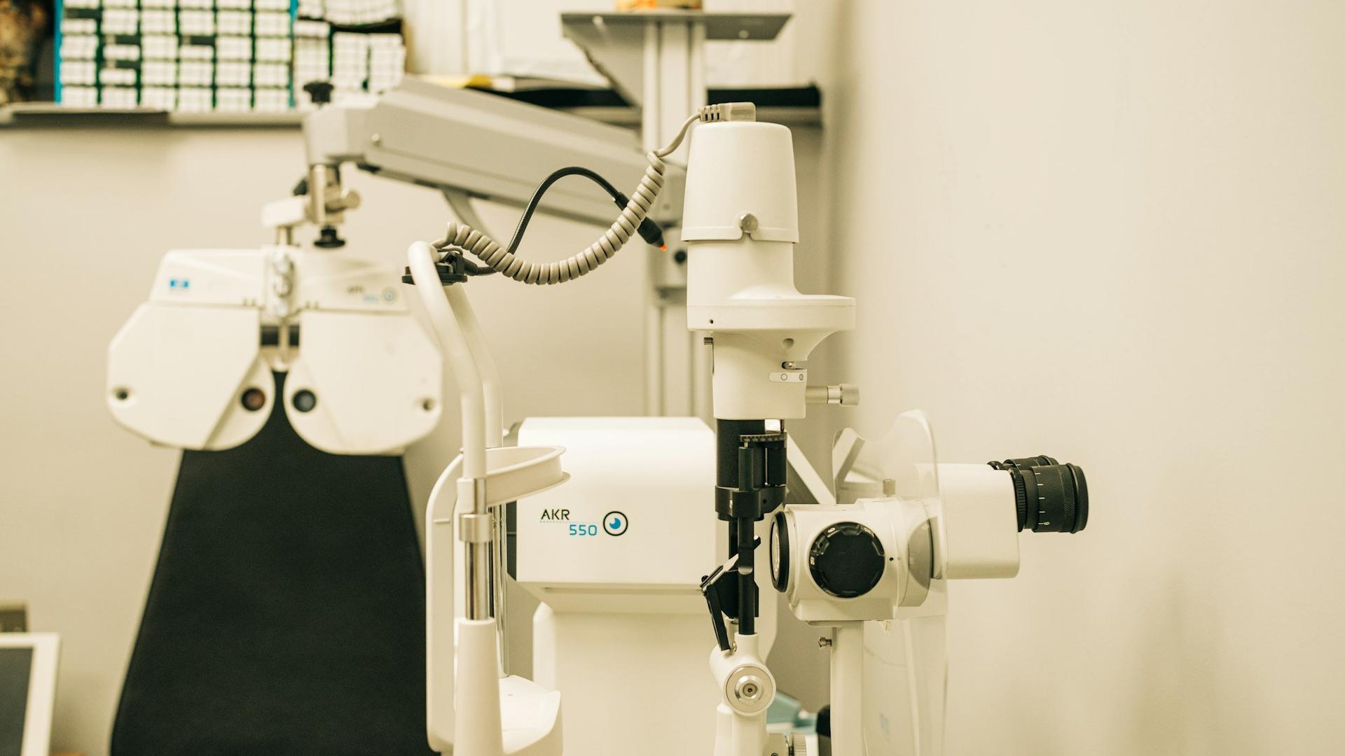 Salle d'examen de vue avec microscope et écran de contrôle, illustrant les services de contrôle et d'adaptation inclus dans le prix d'un opticien indépendant.