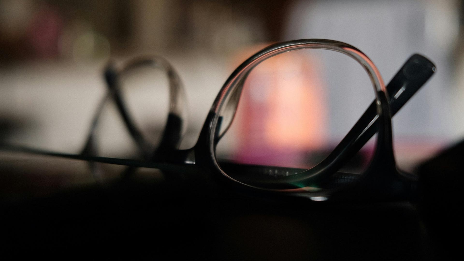 Lunettes à monture noire sur fond sombre, gros plan d'une monture à régler