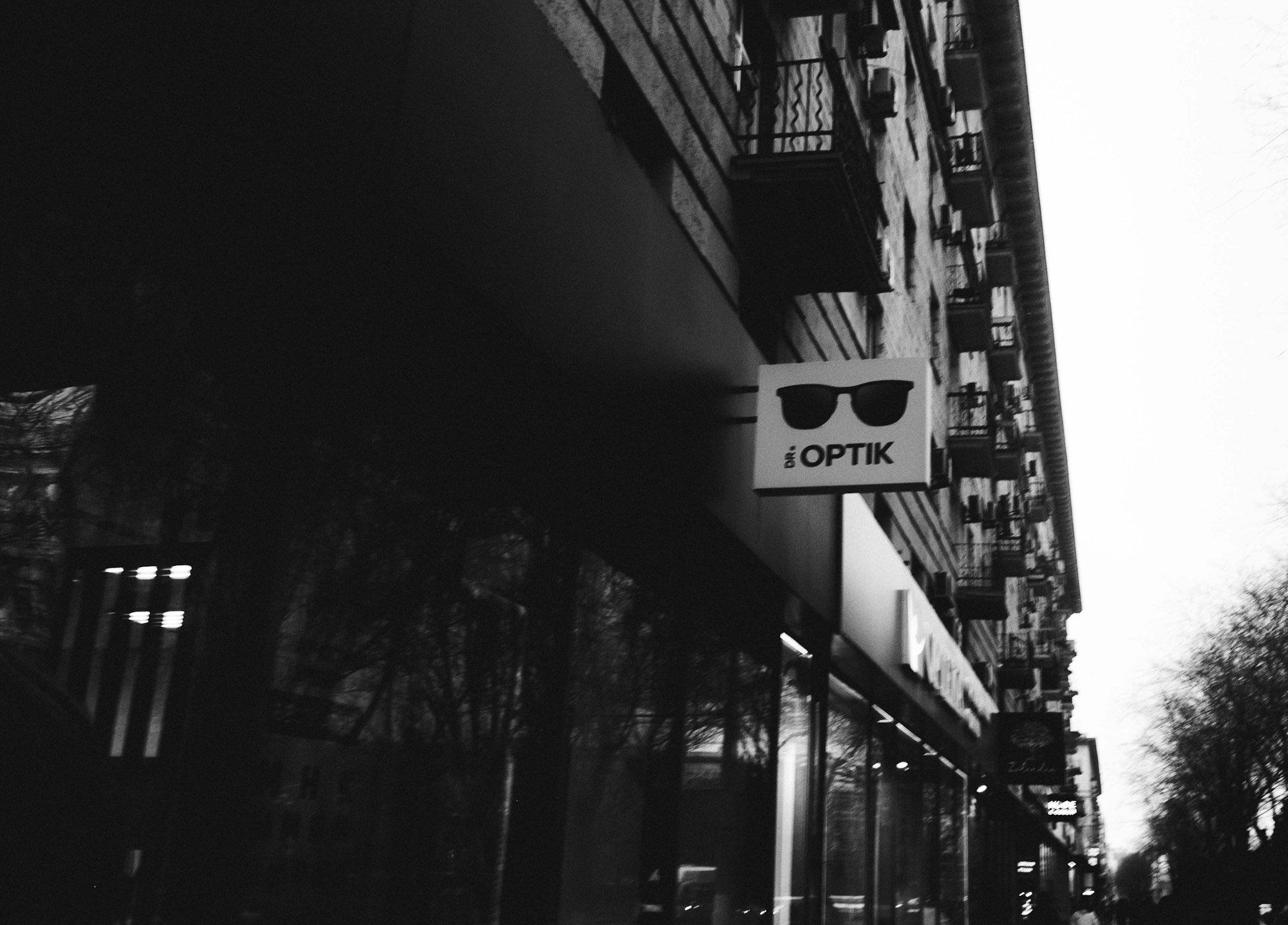 Enseigne d'une boutique d'optique avec logo de lunettes de soleil, commerce de proximité