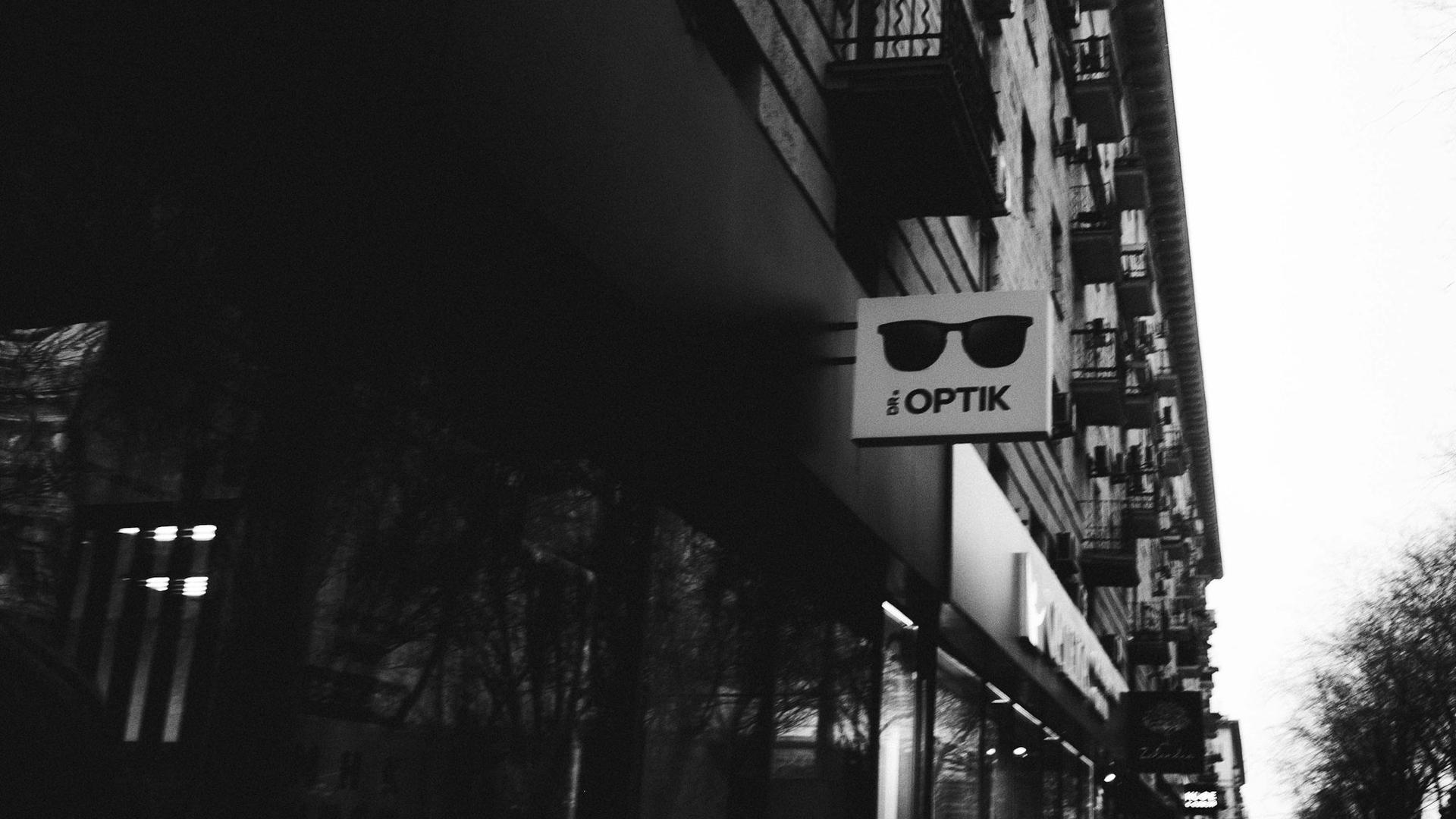 Enseigne d'une boutique d'optique avec logo de lunettes de soleil, commerce de proximité