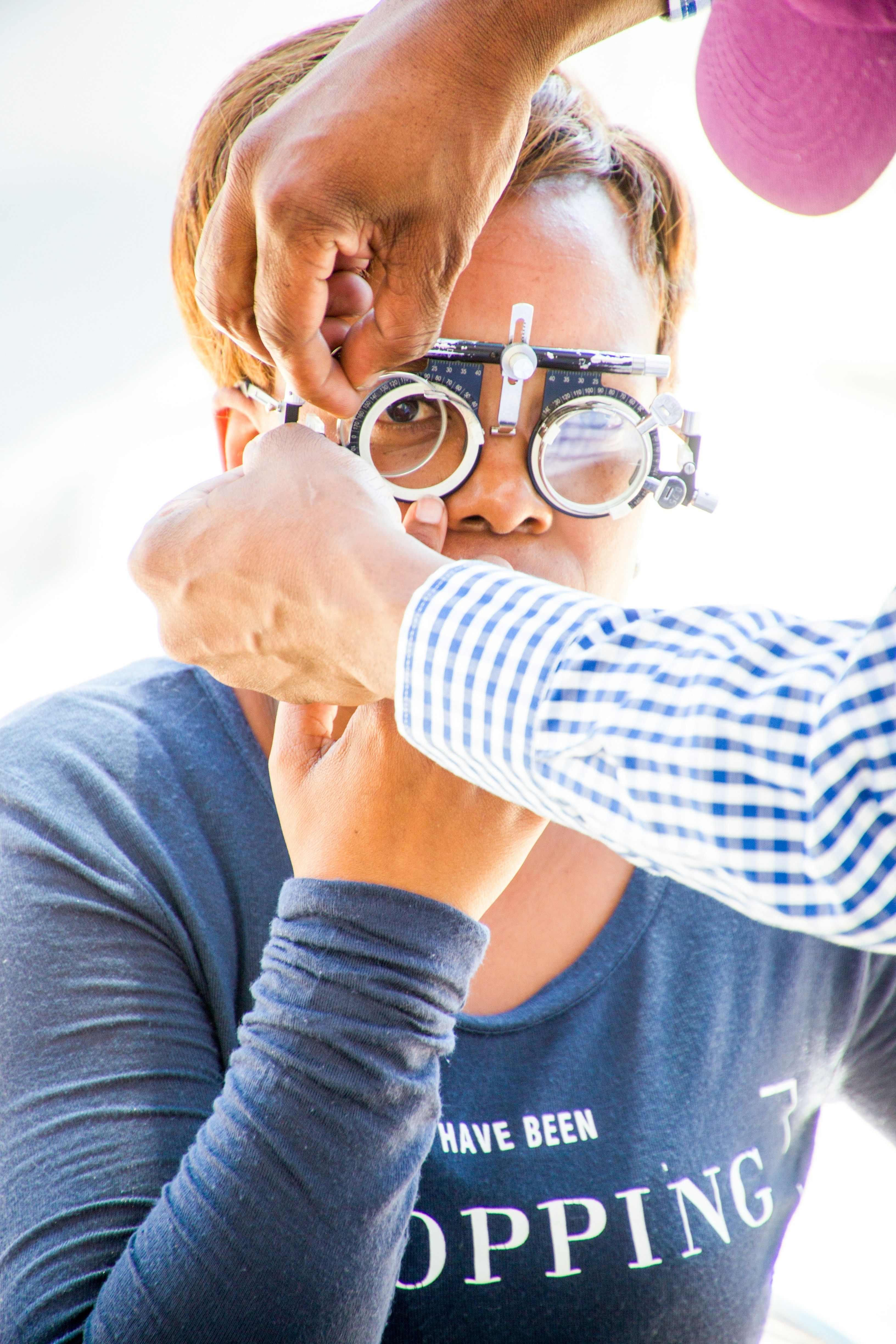 Personne portant des lunettes-loupe lors d'un examen de la vue chez l'ophtalmologiste