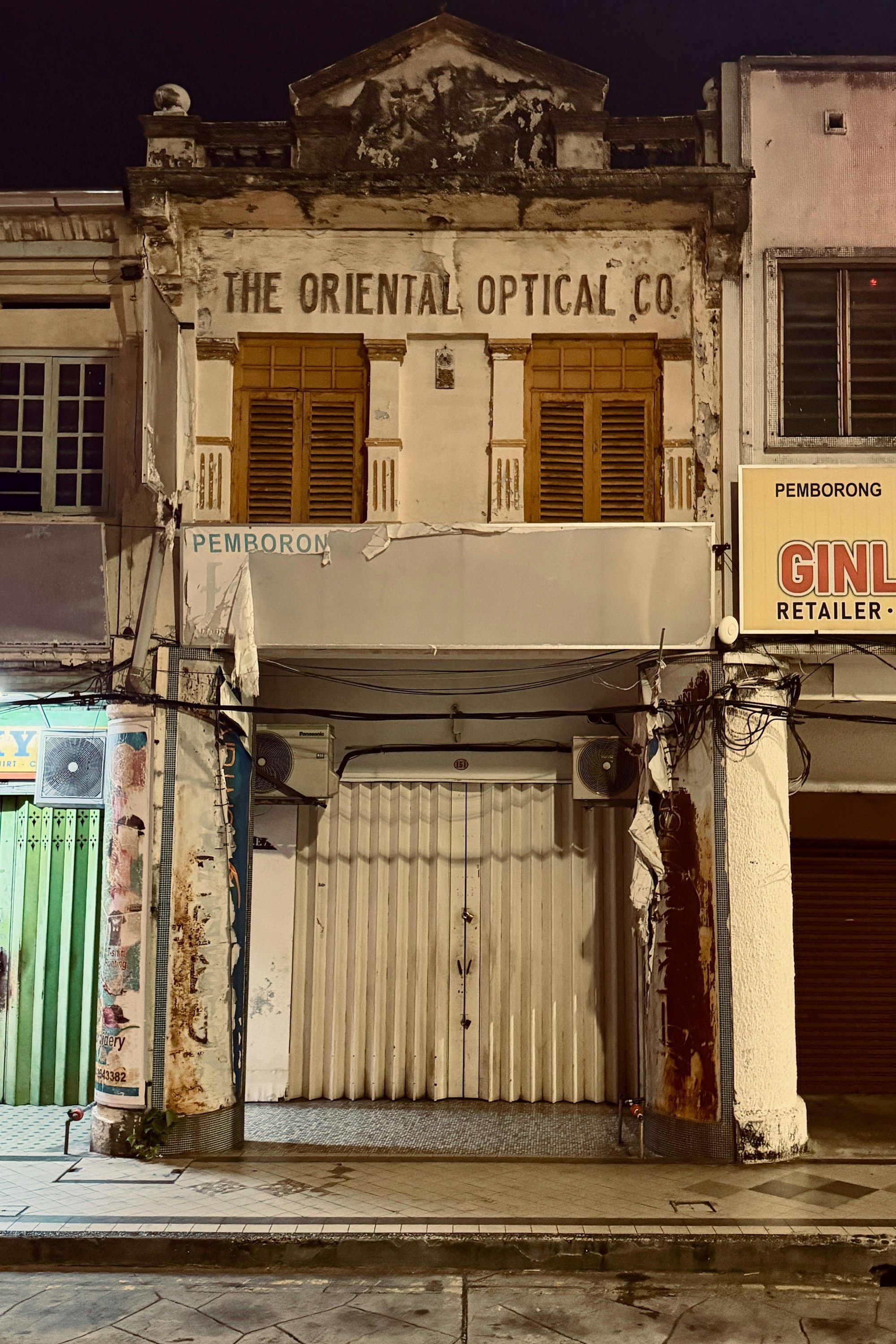 Façade d'une boutique d'optique à l'ancienne avec son enseigne, illustrant l'ancrage local et le savoir-faire d'atelier d'un opticien indépendant.
