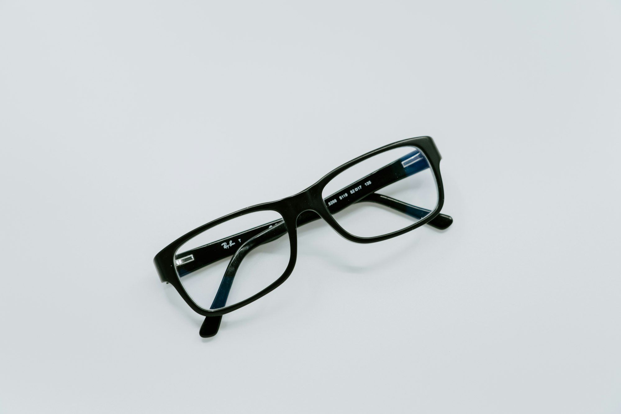 Lunettes à monture noire posées sur une surface claire, le budget d'une consultation pour un œil qui saute