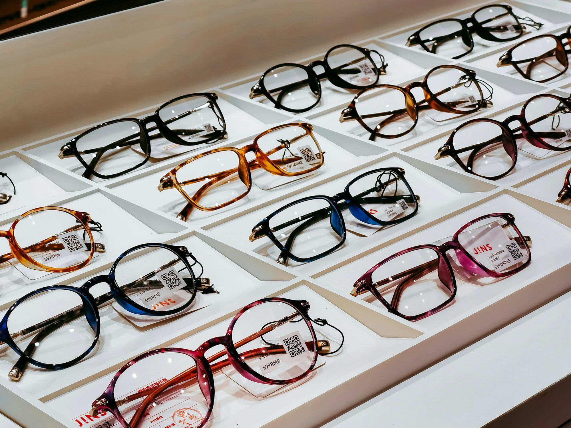 Présentoir de montures de lunettes aux formes et couleurs variées dans un magasin d'optique