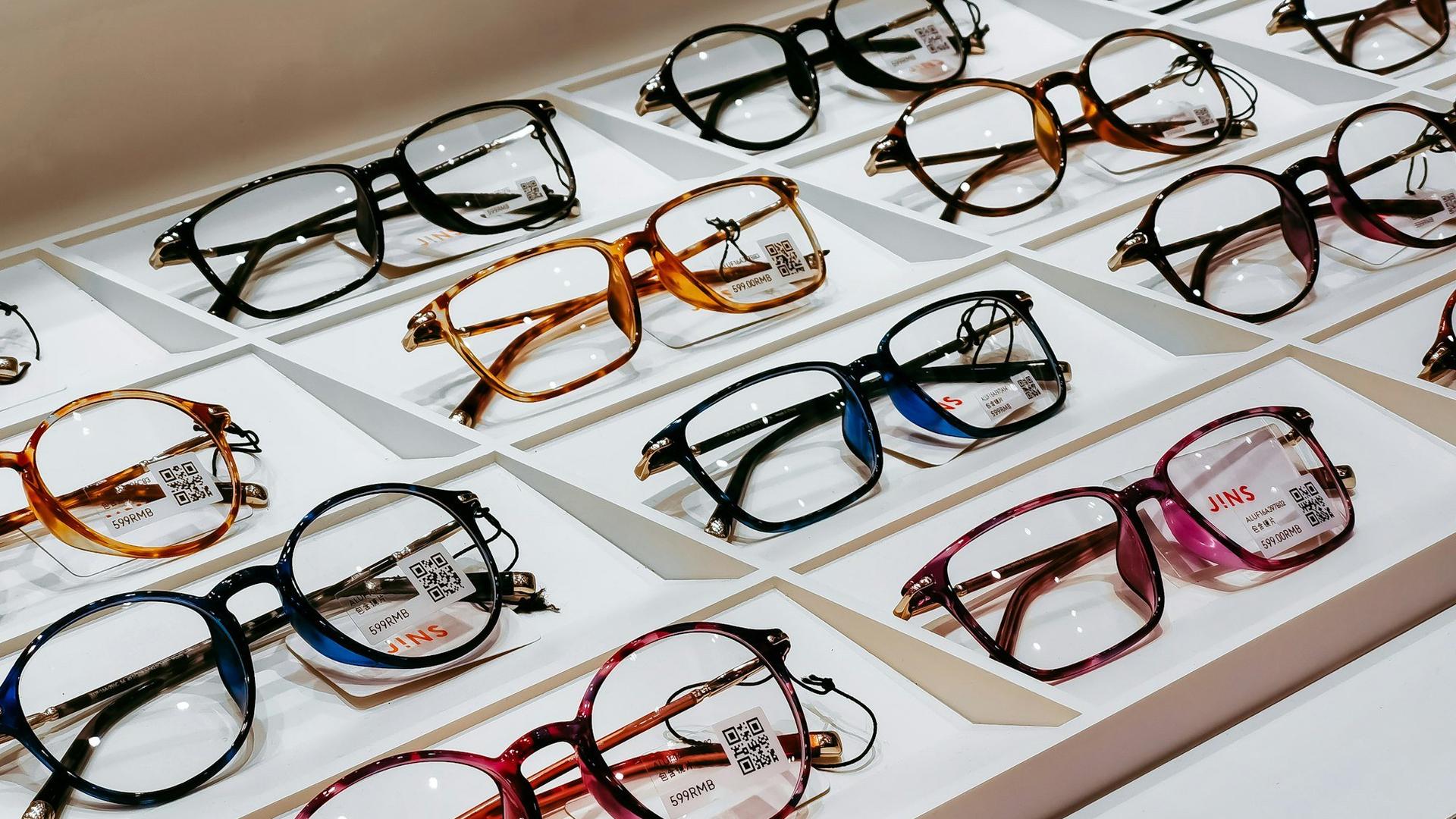 Présentoir de montures de lunettes aux formes et couleurs variées dans un magasin d'optique