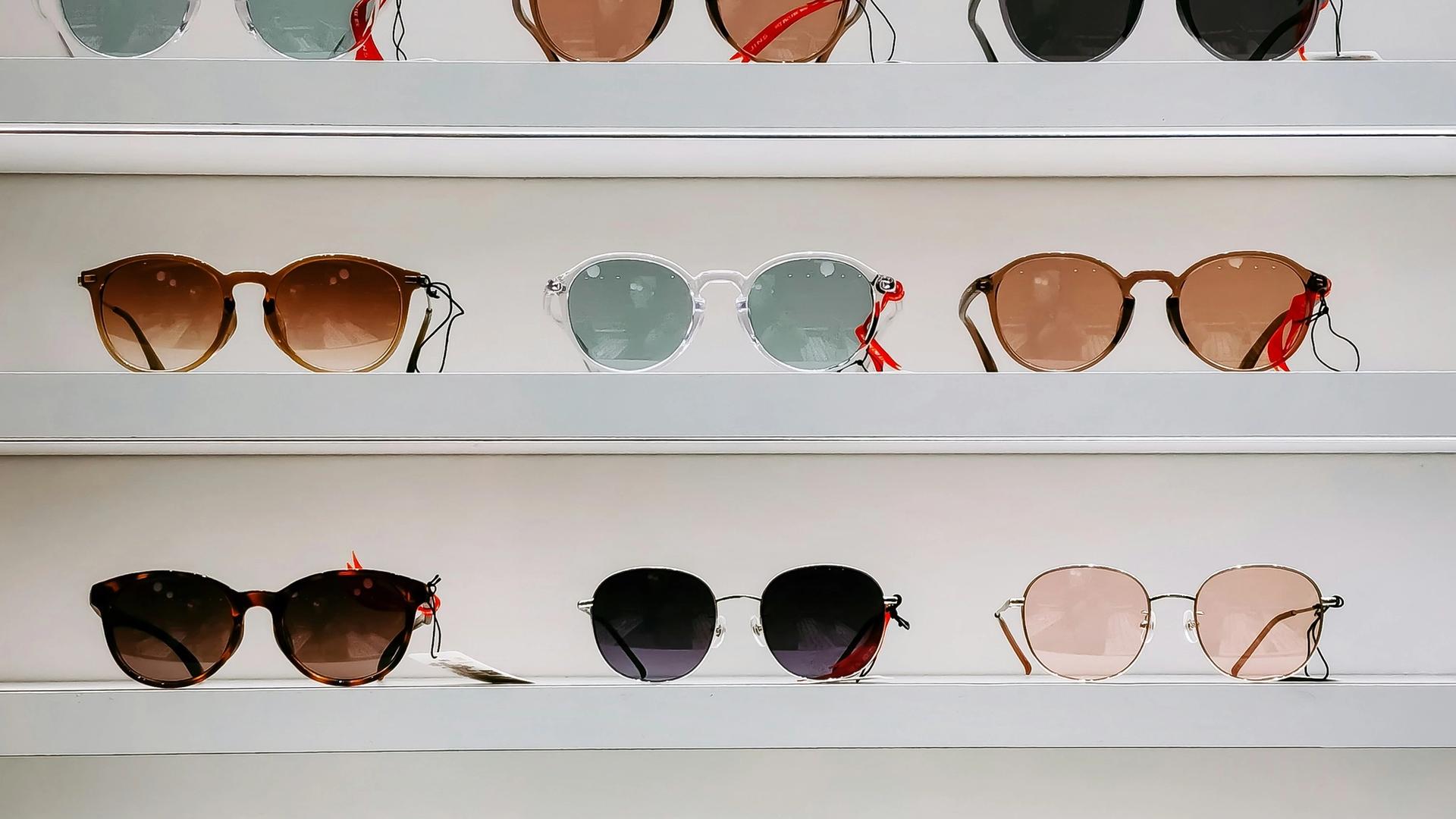 Paire de lunettes de soleil noires posée sur une surface blanche, élégance et style