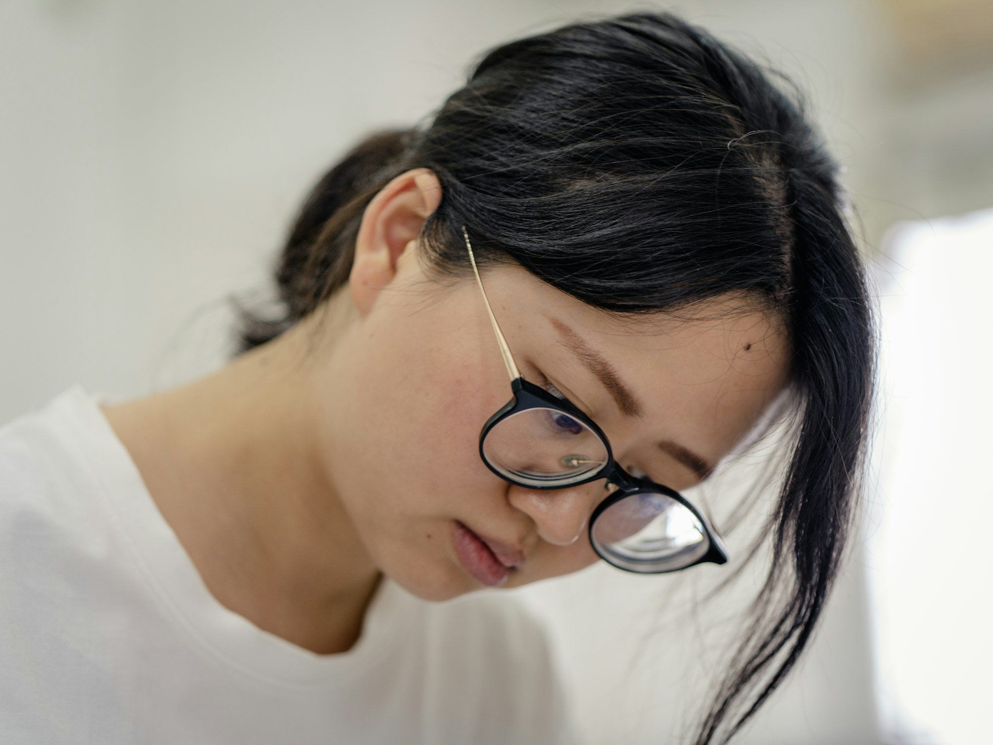Une cliente souriante portant des lunettes à monture argentée, dans une boutique d'optique.