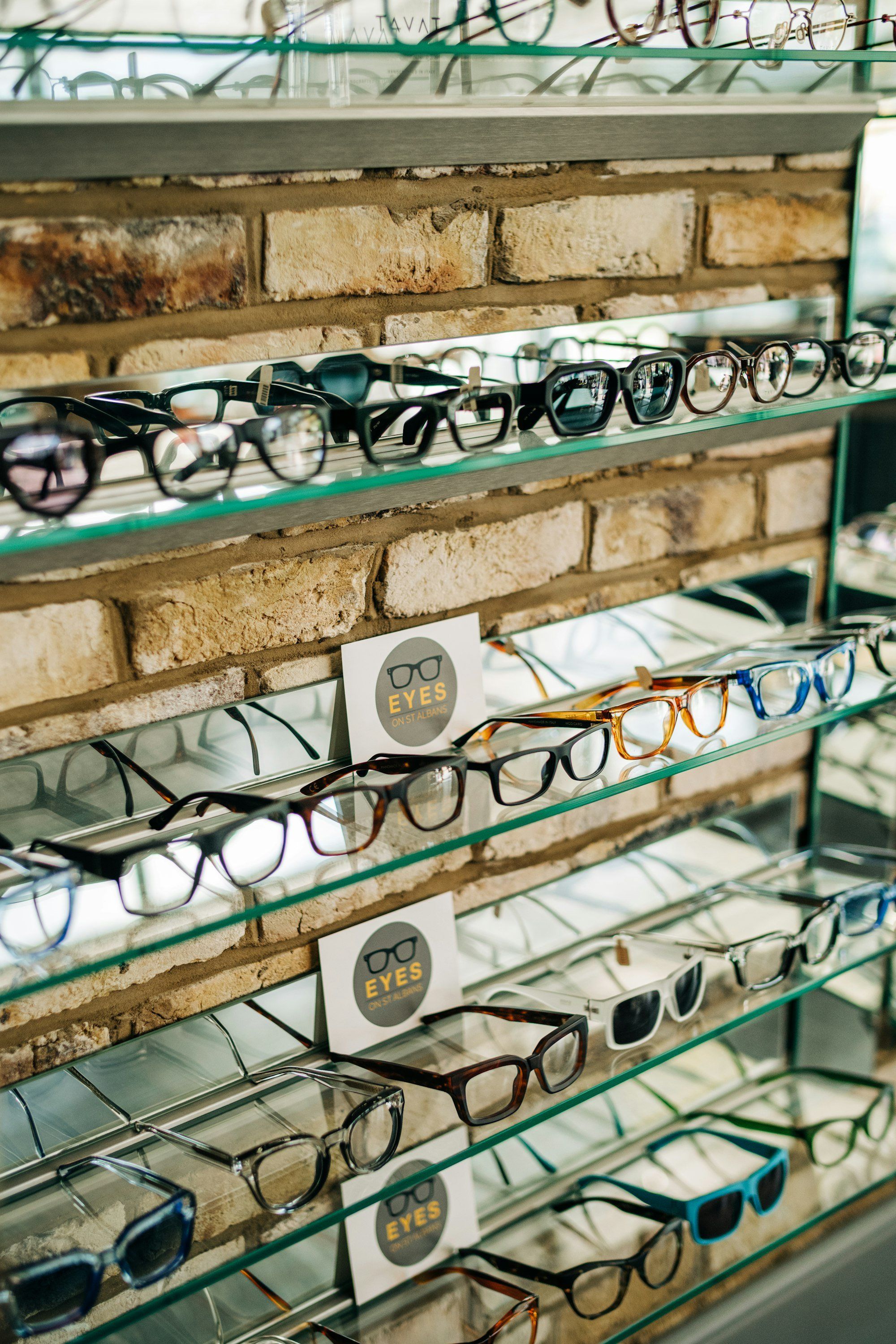 Présentoir rempli de lunettes dans un magasin d'optique, illustrant la vitrine d'un opticien indépendant